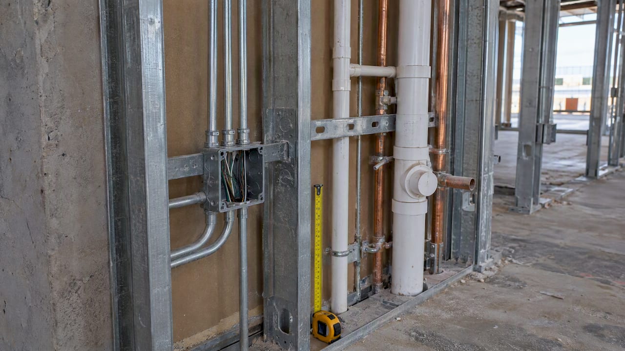 Exposed conduit and plumbing rough-in with scale